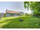 Large backyard surrounded by a metal fence, featuring a stone fire pit at 10763 Zimmerman Ln, Indianapolis, IN 46231