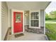 Charming front porch with a red door and stacked stone details at 10763 Zimmerman Ln, Indianapolis, IN 46231