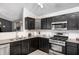 Well-lit kitchen features stainless steel appliances, dark wood cabinets, and granite countertops at 10763 Zimmerman Ln, Indianapolis, IN 46231