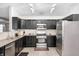 Modern kitchen featuring stainless steel appliances, granite countertops, and dark cabinetry at 10763 Zimmerman Ln, Indianapolis, IN 46231