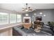 Comfortable living room with a brick fireplace, dark leather furniture, and ceiling fan at 10763 Zimmerman Ln, Indianapolis, IN 46231