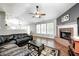 Comfortable living room with a brick fireplace, dark leather furniture, and ceiling fan at 10763 Zimmerman Ln, Indianapolis, IN 46231