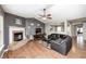 Comfortable living room with a brick fireplace, dark leather furniture, and ceiling fan at 10763 Zimmerman Ln, Indianapolis, IN 46231