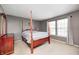 Spacious bedroom with a large four poster bed, carpet floors, and plenty of natural light at 10763 Zimmerman Ln, Indianapolis, IN 46231