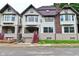 Charming three-story home featuring a red staircase leading to a covered front porch with a garage underneath at 122 E 27Th St, Indianapolis, IN 46205