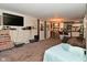 Open living room featuring carpeted floors, a mounted tv, with an open view to the kitchen with bar stool seating at 122 E 27Th St, Indianapolis, IN 46205