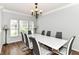 Elegant dining room featuring a bright chandelier, a white dining table and seating for six at 12612 Majestic Way, Fishers, IN 46037