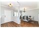 Formal dining room with wood floors, modern chandelier, and sleek white dining table with seating for six at 12612 Majestic Way, Fishers, IN 46037