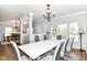 Open concept dining room features a large white table, seating for six, and hardwood floors at 12612 Majestic Way, Fishers, IN 46037
