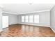 Bright empty room with hardwood floors, neutral walls, and multiple windows allowing natural light to fill the space at 12612 Majestic Way, Fishers, IN 46037