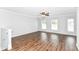 Open and airy empty room featuring hardwood floors, neutral paint, and natural light from the large windows at 12612 Majestic Way, Fishers, IN 46037