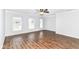 Spacious living room boasts hardwood floors, neutral paint, and natural light from large windows at 12612 Majestic Way, Fishers, IN 46037