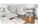 Bright living room featuring a white leather sofa, a glass-topped coffee table, and hardwood floors at 12612 Majestic Way, Fishers, IN 46037