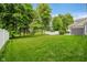 Expansive backyard featuring a well-manicured lawn, mature trees, and white fencing for privacy at 1274 Timber Bluff Rd, Westfield, IN 46074