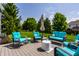 Cozy back deck with turquoise outdoor seating and a well-manicured lawn and trees at 14805 Chamberlain Dr, Westfield, IN 46074