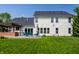 A vast backyard featuring a well-manicured lawn, a deck with patio furniture, and trees at 14805 Chamberlain Dr, Westfield, IN 46074