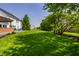 Large backyard with mature trees, a well-kept lawn, and a view of the home's deck at 14805 Chamberlain Dr, Westfield, IN 46074