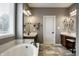 Bright bathroom featuring a soaking tub, double vanity with marble countertops, and decorative mirrors at 14805 Chamberlain Dr, Westfield, IN 46074