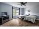 Spare bedroom with two twin beds, dark wood floor, and natural light from the large picture window with blackout curtains at 14805 Chamberlain Dr, Westfield, IN 46074