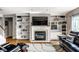 Comfortable living room features built-in bookcases surrounding a fireplace, with hardwood floors and leather furniture at 14805 Chamberlain Dr, Westfield, IN 46074