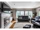 Cozy living room featuring a fireplace, large windows, comfortable leather furniture and hardwood floors at 14805 Chamberlain Dr, Westfield, IN 46074