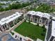 Aerial view of modern apartment buildings with a central lawn and parking, set in a suburban landscape at 15 W Executive Dr # 101, Carmel, IN 46032