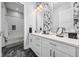 Bathroom featuring dual sinks, modern vanity, and tub-shower combination, floral accent wall at 15 W Executive Dr # 101, Carmel, IN 46032