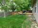 Backyard featuring a wooden deck with a grill and seating next to a fenced in yard with green grass at 1612 Prairieview Ln, Greenfield, IN 46140