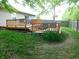 A backyard with green grass featuring a wooden deck with grill and outdoor seating at 1612 Prairieview Ln, Greenfield, IN 46140