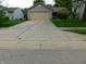 Home exterior with a large driveway and mature trees at 1612 Prairieview Ln, Greenfield, IN 46140