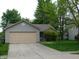 Exterior shot of home featuring a two-car garage and mature trees at 1612 Prairieview Ln, Greenfield, IN 46140