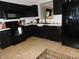 Modern kitchen with black appliances, including a refrigerator and microwave, and tile flooring at 1612 Prairieview Ln, Greenfield, IN 46140