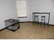Bonus room with tile floors that features a bar table with stools and a large dog kennel at 1612 Prairieview Ln, Greenfield, IN 46140