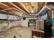 Unfinished basement space with exposed wood beams, brick walls, and unfinished floors at 1616 N Delaware St, Indianapolis, IN 46202