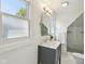 Bright bathroom featuring a gray vanity, a shower with glass doors, and a sunny window at 1616 N Delaware St, Indianapolis, IN 46202