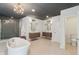 Spacious bathroom featuring a freestanding tub, patterned glass shower, dual vanities, and modern lighting at 1616 N Delaware St, Indianapolis, IN 46202