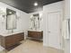 Modern bathroom with dual vanities, herringbone tile flooring, and sleek fixtures under a dark-painted ceiling at 1616 N Delaware St, Indianapolis, IN 46202