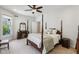 Bright bedroom boasts a four-poster bed, ceiling fan, and elegant vanity with a well-lit mirror at 1616 N Delaware St, Indianapolis, IN 46202