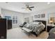 Bright primary bedroom with ceiling fan, bench, and view of backyard through shuttered windows at 1616 N Delaware St, Indianapolis, IN 46202