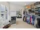Organized walk-in closet with custom shelving, hanging racks, mini-refrigerator, and a view into the bedroom at 1616 N Delaware St, Indianapolis, IN 46202