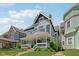 Attractive two-story gray home showcasing a inviting front porch with white railing and lush lawn at 1616 N Delaware St, Indianapolis, IN 46202