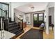 Welcoming foyer with hardwood floors, black staircase, chandelier and view of the front doors at 1616 N Delaware St, Indianapolis, IN 46202