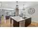 View of the kitchen island that features a stainless steel dishwasher and adjacent to the living area at 1616 N Delaware St, Indianapolis, IN 46202