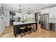 Kitchen with a dark island and white cabinets with stainless steel appliances and barstool seating at 1616 N Delaware St, Indianapolis, IN 46202