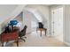 An upper-level office space with carpeted floors, sloped ceilings, and a desk at 1616 N Delaware St, Indianapolis, IN 46202