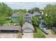 Aerial view of the home's back exterior and detached two-car garage surrounded by a wood fence, grass, and trees at 1616 N Delaware St, Indianapolis, IN 46202