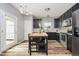 Modern kitchen with black cabinets, stainless steel appliances, wood floors and center butcher block island with seating at 16768 Maraschino Dr, Noblesville, IN 46062