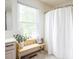 Bright bathroom features a window, decorative bench, and a shower with curtain creating a clean and refreshing space at 1680 Arbor Springs Dr, Brownsburg, IN 46112