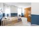 bedroom with two windows, blue accent wall, and wooden furniture offering a comfortable and stylish space at 1680 Arbor Springs Dr, Brownsburg, IN 46112