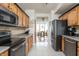 Well-lit kitchen featuring stainless steel appliances and wood cabinetry leading to dining area at 1680 Arbor Springs Dr, Brownsburg, IN 46112